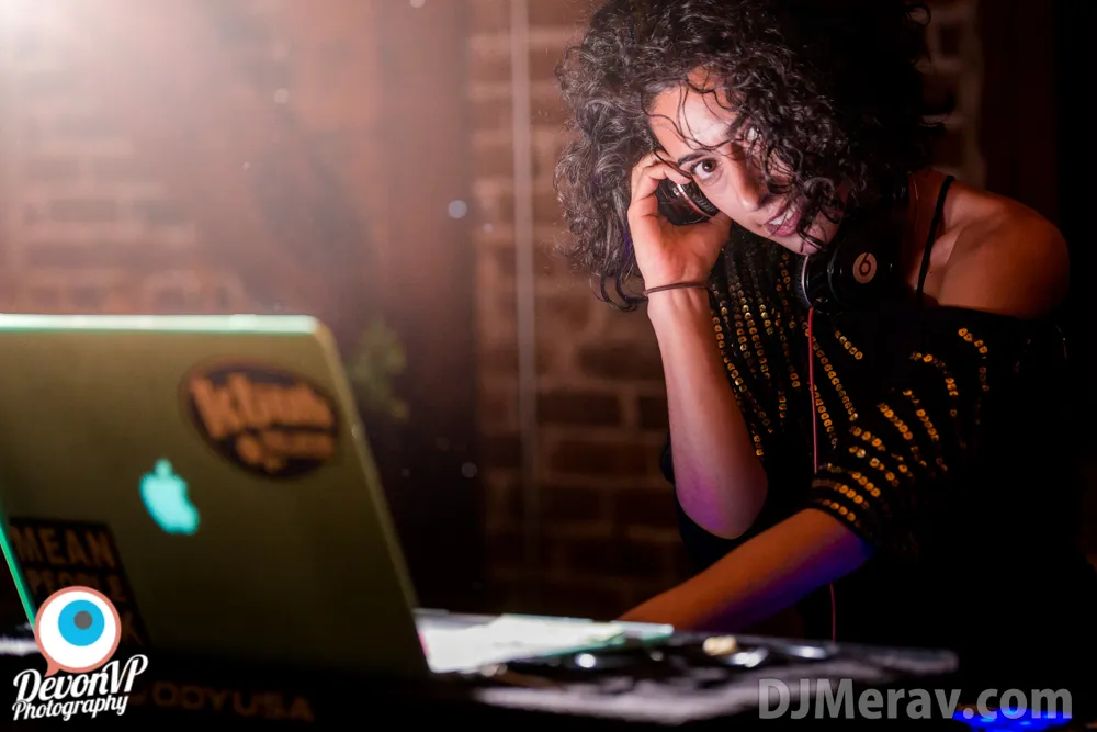 At the laptop in a brick-walled bar