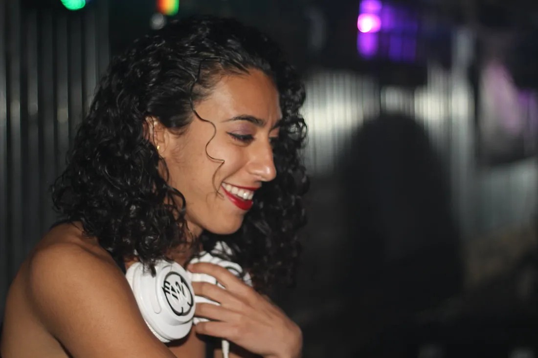 Merav with headphones, mid-set