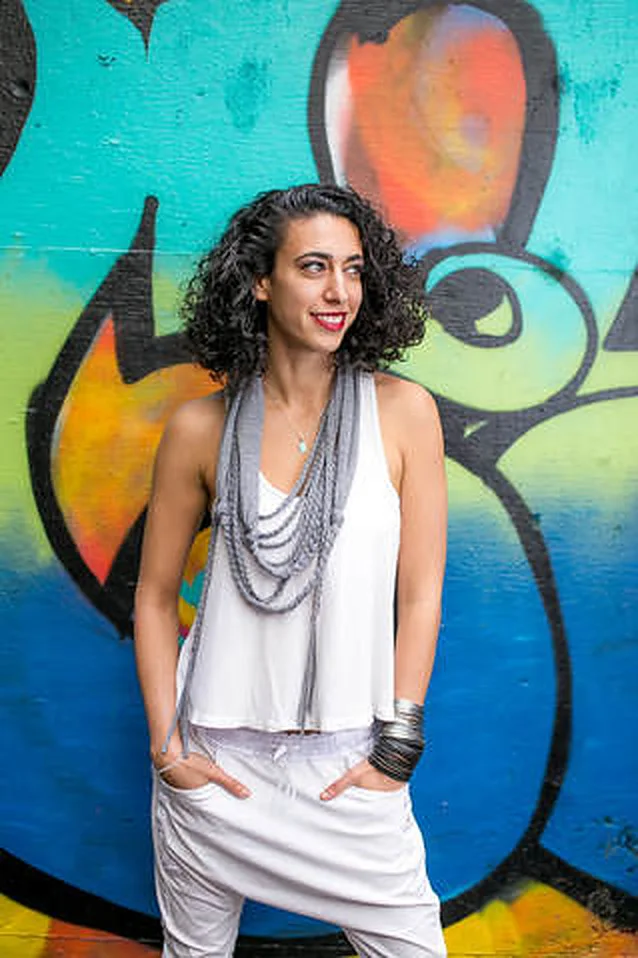 DJ Merav in front of a graffiti wall